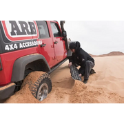 Man digging into sand with ARB Tred Pro Black/Black in jeep