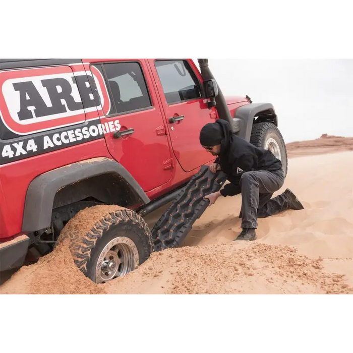 Man pushing tire on jeep displaying ARB Tred Pro Black/Black.