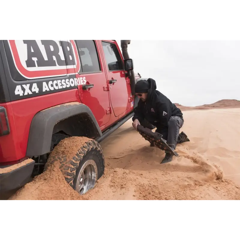 Man digging in sand in ARB Tred Pro Black/Black Board/Black Nodules.
