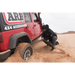 Man digging at sand in a jeep with ARB Tred Pro Green recovery board