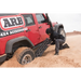 ARB Tred Pro recovery board in Gun Metal Grey - man pushing tire on jeep