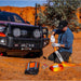 Man working on vehicle with ARB Weekender Recovery kit.