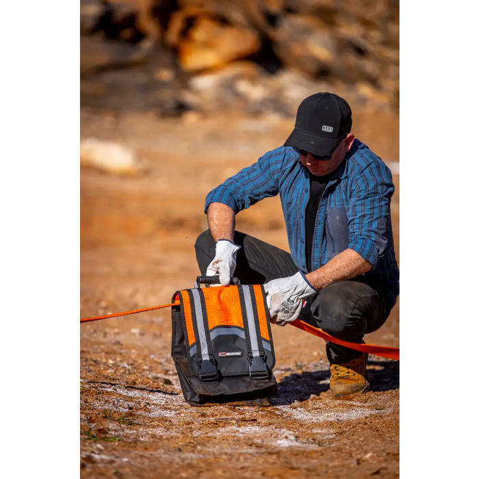 Man kneeling with backpack - ARB Weekender Recovery Kit - 17600lb Recovery Strap/4.75T Shackles