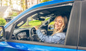 Woman driving car with avs window deflectors for fresh air flow