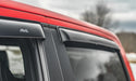 Red van with black roof rack featuring avs original ventvisor window deflectors for toyota hilux double cab