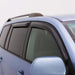 Blue car with black roof rack featuring avs 05-10 jeep grand cherokee ventvisor outside mount window deflectors 4pc - smoke