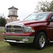 Red truck parked next to lighthouse with avs aeroskin low profile hood shield - chrome