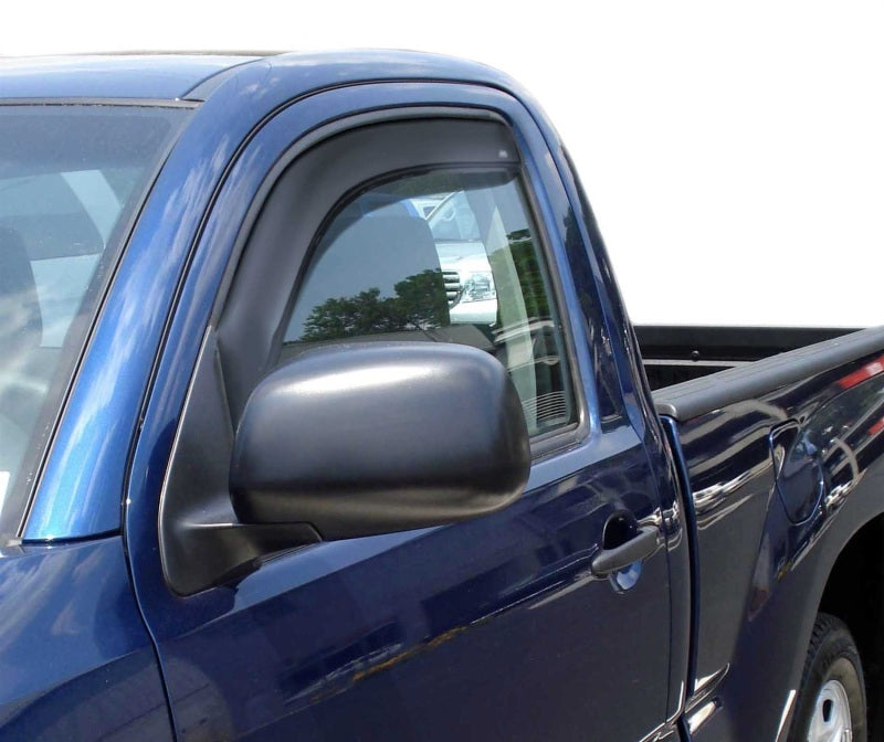 Blue truck with dog in bed next to avs tacoma access cab window deflector for fresh air