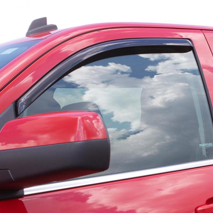 Red car with sky reflection on side window, showcasing avs toyota tacoma standard cab ventvisor in-channel window deflectors in smoke color