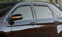 Brown car parked in front of stone wall with avs window deflectors for fresh air flow