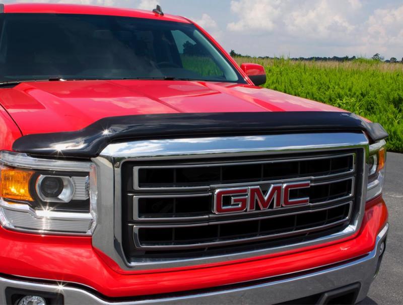 Red truck parked in parking lot with avs bugflector ii hood shield - smoke installed