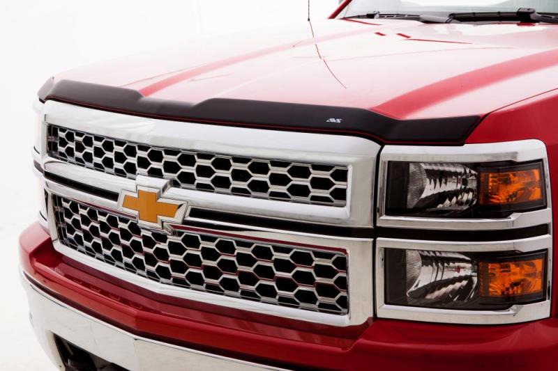 Red truck with black grill featuring avs aeroskin low profile hood shield - matte black. No special hardware required