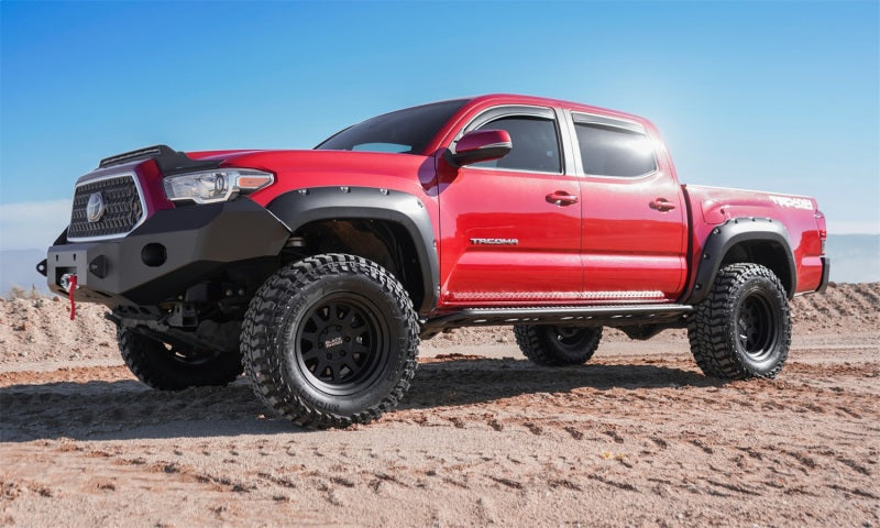 Red truck on dirt road with avs toyota tacoma double cab ventvisor in-channel front & rear window deflectors providing fresh air