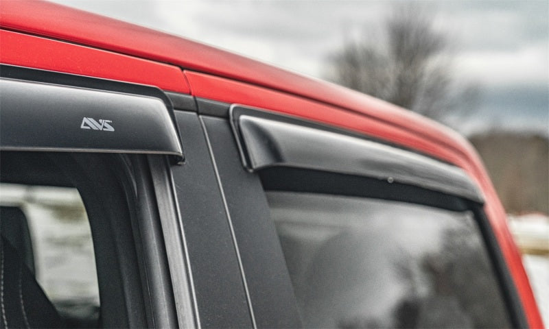 Red van with black roof rack featuring avs original ventvisor window deflectors for fresh air