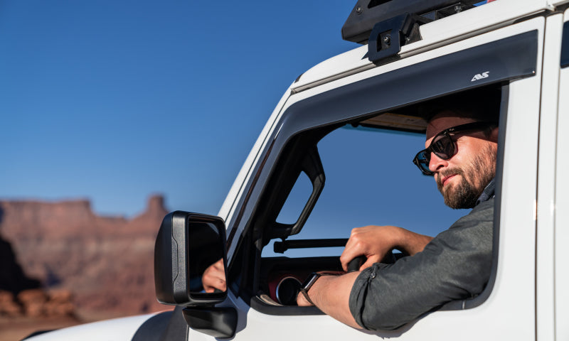 Man in truck driving through desert with avs 2018 jeep wrangler unlimited ventvisor low profile window deflectors - smoke