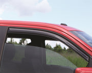 Man driving in red car with avs window deflector