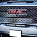 Close-up of gmc logo on truck grille with 30in grille led light bar kit by baja designs