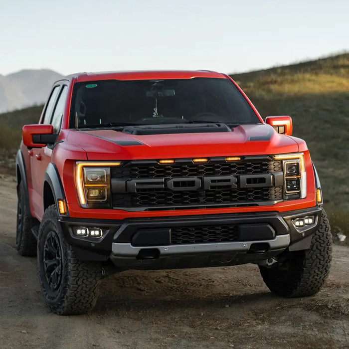 Red truck driving down dirt road, Baja Designs Raptor S2 SAE Dual Fog Pocket Light Kit.