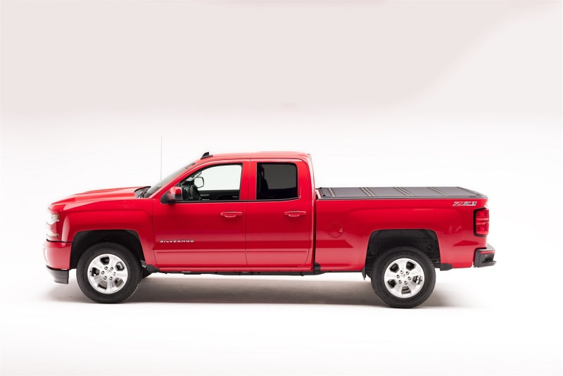 Red truck parked on white surface - bak 04-14 chevy silverado 1500 5ft 8in bed bakflip mx4 matte finish