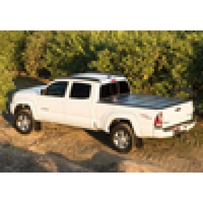 White truck parked in dirt next to BAK 05-15 Toyota Tacoma truck bed cover.