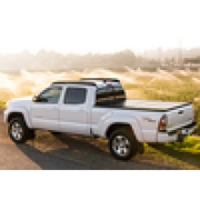 White truck driving down dirt road - BAK 05-15 Toyota Tacoma 5ft Bed BAKFlip G2.