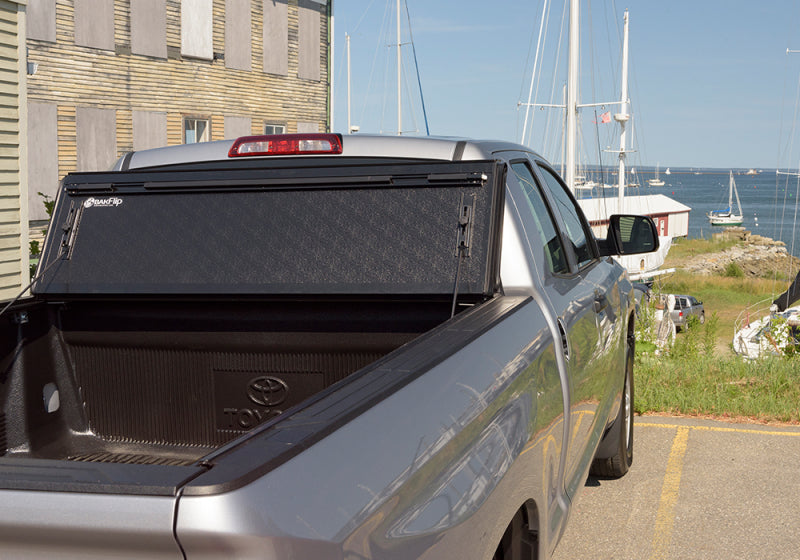 Toyota tundra with bakflip g2 parked in lot with boat in background