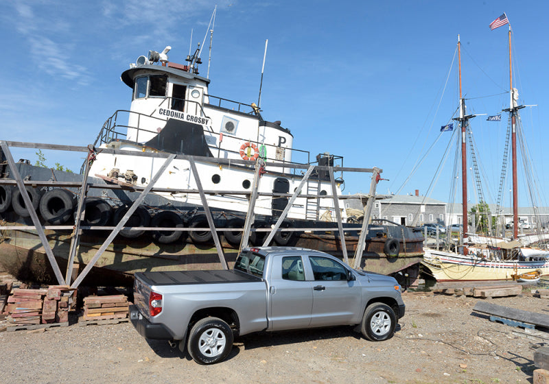 Toyota tundra with bakflip g2 parked in front of boat