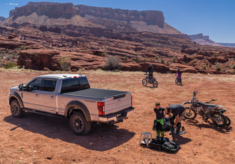 Ford super duty revolver x4s bed cover with truck in desert and bikers