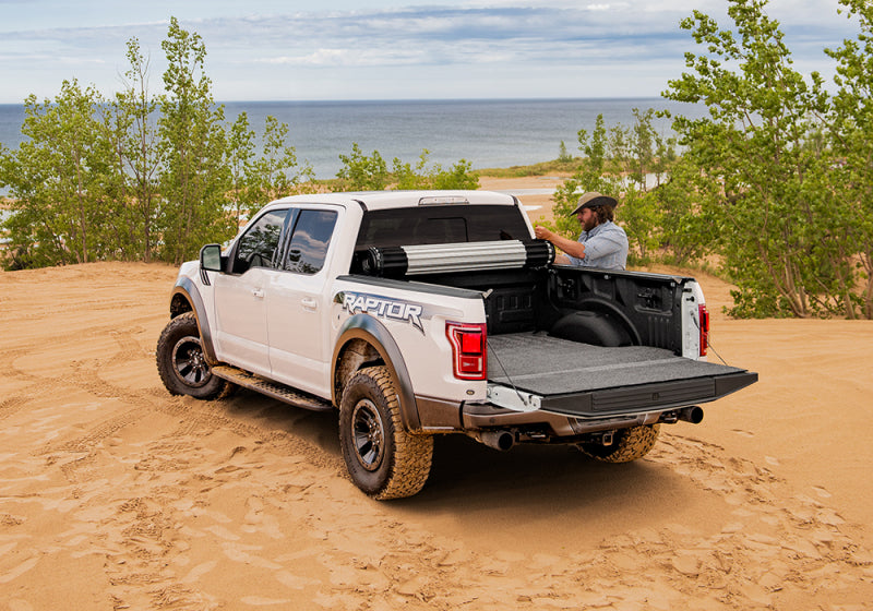 Man loading truck bed on sand - bak 15-20 ford f-150 revolver x2 installation instructions