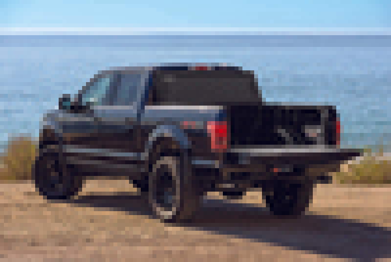 Black truck driving down a dirt road - bak 15-20 ford f-150 6ft 6in bed bakflip mx4 matte finish