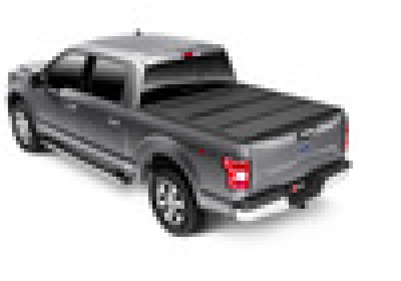 Black truck with red tail light featuring bak 15-20 ford f-150 6ft 6in bed bakflip mx4 matte finish