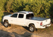 White truck parked on dirt road with bak 16-20 nissan titan 5ft 6in bed bakflip g2