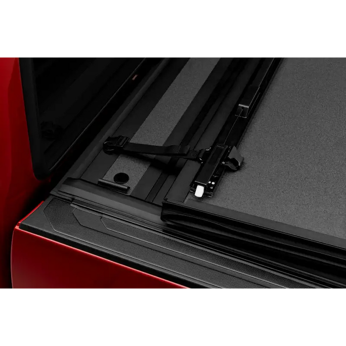 Close up of black BAKFlip MX4 cover on red Toyota Tacoma truck bed