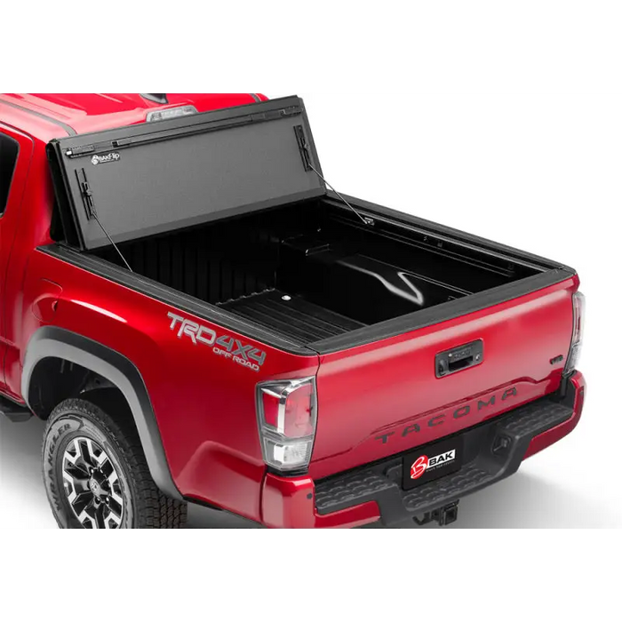 Red truck with bed cover open: BAKFlip MX4 installation instructions for 16-20 Toyota Tacoma.