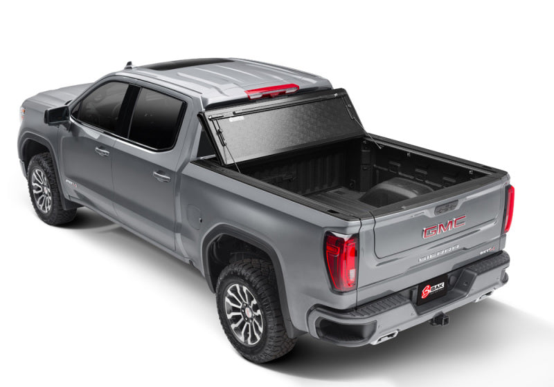 Rear view of a 2019 chevrolet titan truck next to bakflip f1 installation instructions