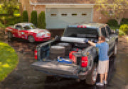 A man and woman standing next to a chevy silverado 5ft 8in bed truck