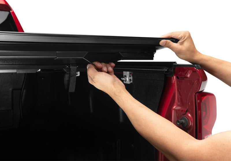 Person installing bakflip g2 truck bed cover on chevy silverado