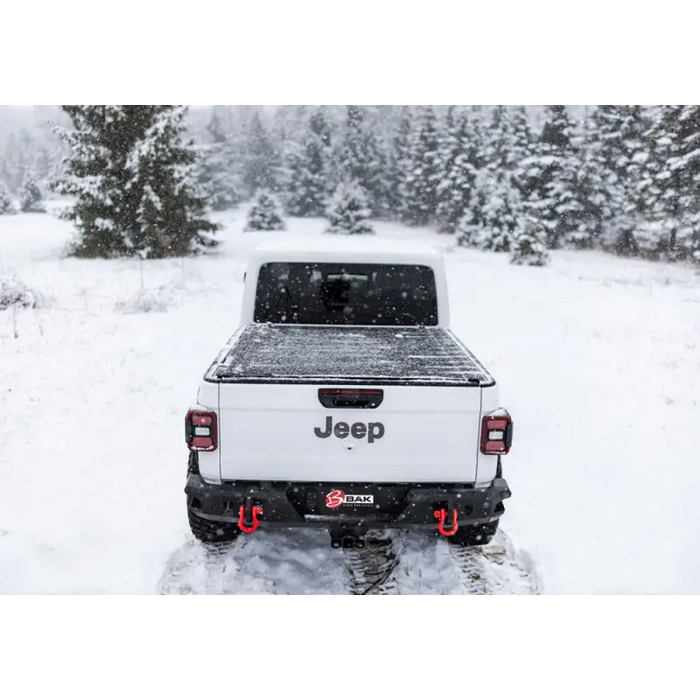 White truck parked in snow with BAK Revolver X4s bed cover.