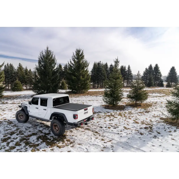 White Jeep parked in snow with BAK 20-21 Jeep Gladiator Revolver X4s 5ft Bed Cover