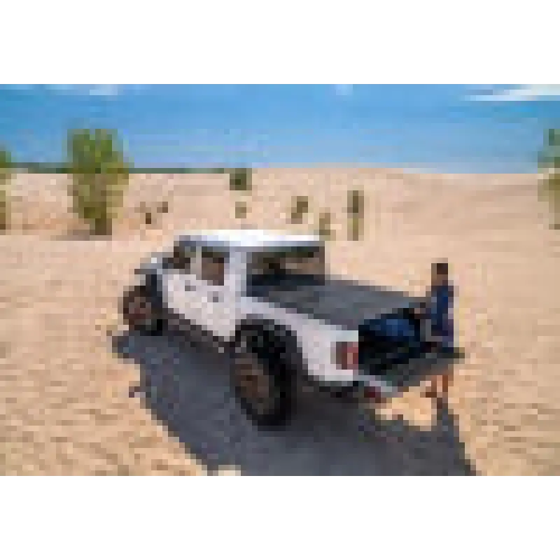 BAK 2020 Jeep Gladiator 5ft Bed BAKFlip MX4 with man standing next to truck in desert