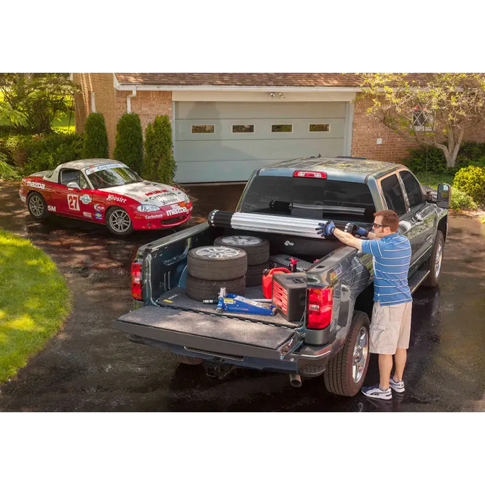 Man loading tools into truck bed of BAK 2020 Jeep Gladiator Revolver X2