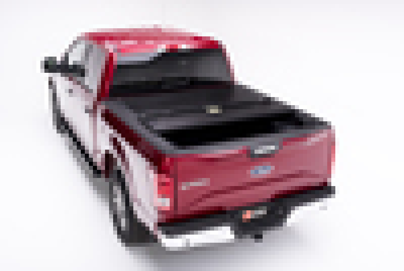 Red and black bakflip f1 6.5ft bed cover for ford f-150 with installation instructions displayed on red car