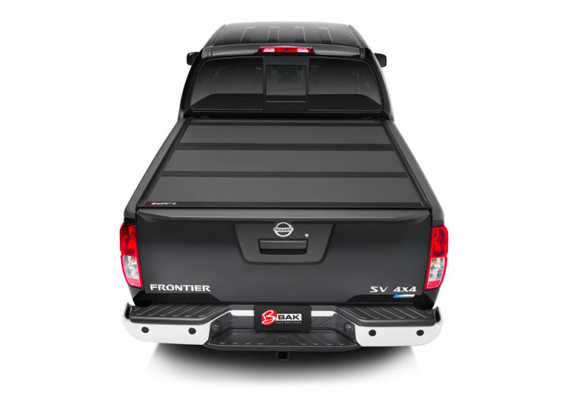 Rear view of black truck bed cover for 2022 nissan frontier - bakflip mx4