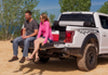 Man and woman sitting on back of white truck with bak 21-22 ford f-150 revolver x2 5.7ft bed cover