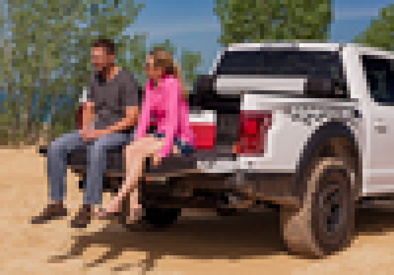 Man and woman sitting on back of white truck with bak 21-22 ford f-150 revolver x2 5.7ft bed cover