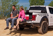 Couple sitting on the back of a white truck with a 5.7ft bed cover