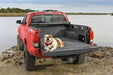 Dog laying in the back of a bedrug bedliner for toyota tacoma trucks