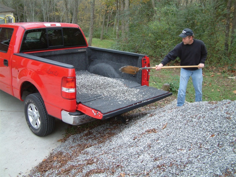 Man loading gravel into bedrug bedliner for gm silverado/sierra 5ft 8in truck with installation instructions