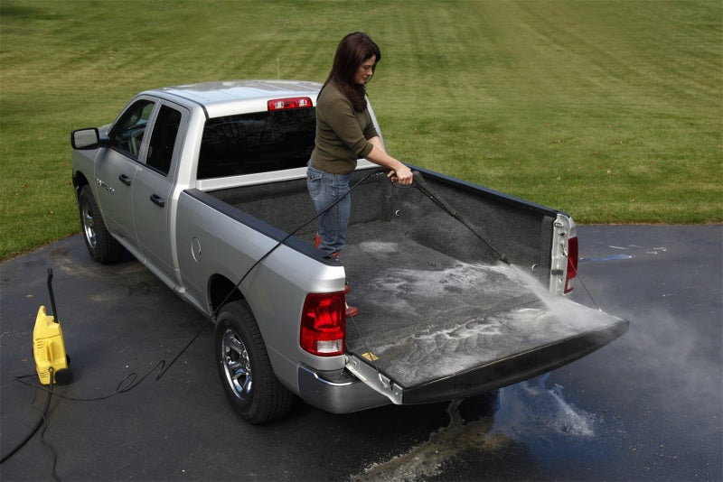 Woman washing a truck with a hose on bedrug 09-18 dodge ram bedliner