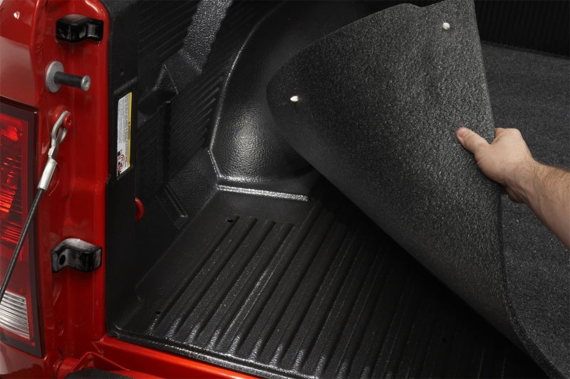 Man installing bedrug drop-in mat in ford f-150 truck bed